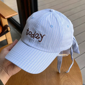 Light blue pinstripe cotton baseball cap with embroidered "today" text and tie back detail.