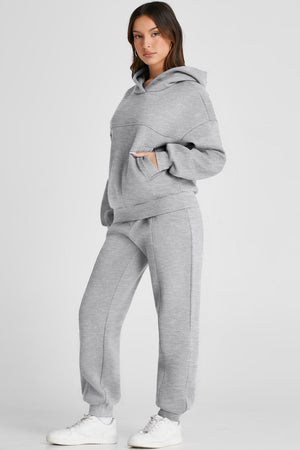 Gray relaxed fit loungewear set with seam detail on hoodie and pants.