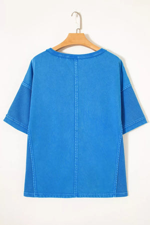 Blue mineral wash cotton tee with contrast mesh sleeves and seam details.