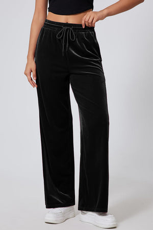 Black velvet palazzo lounge trousers with drawstring waist and wide legs.