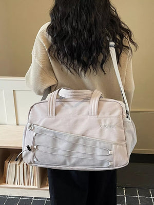 Grey nylon travel organizer bag with bungee cord detail and mesh pockets.