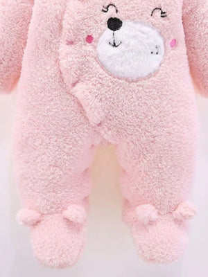 Blush pink plush baby one-piece with bear ears hood and footie details.