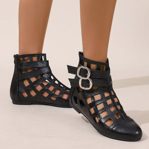 Black ankle boots with cutout design and double buckle straps.