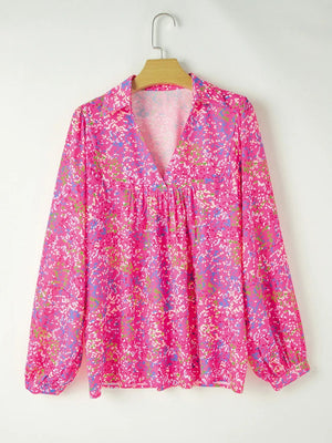 Hot pink graphic mesh sleeve blouse with V-neck and gathered waist.