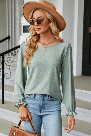 Light green textured puff sleeve blouse with ruffled cuffs and crew neck.