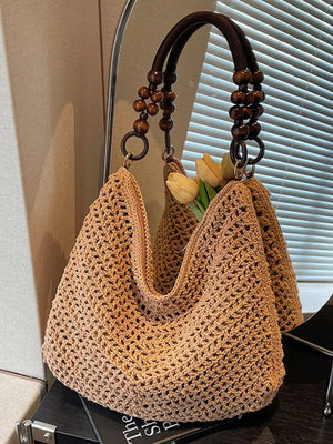Khaki textured knit shoulder bag with wooden bead handle and metal ring detail.