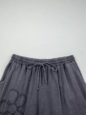 Maternity cropped wide-leg pants in charcoal cotton with floral applique and drawstring waist.