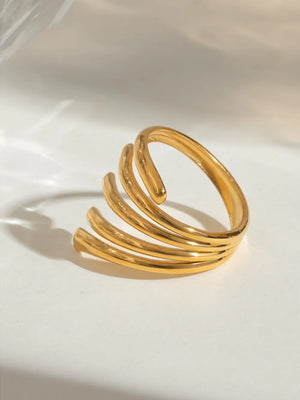 Sculptural gold-plated ribbed ring with multiple stacked bands.