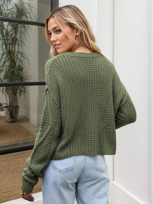 Moss green acrylic cable knit cropped sweater with textured stitch detail.