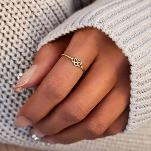 Gold intertwined heart and infinity ring with small diamonds on a twisted band.