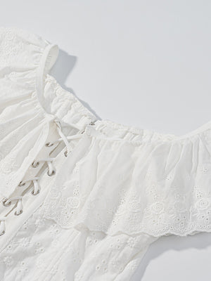 White eyelet lace-up corset tank top with ruffle trim and delicate floral embroidery.