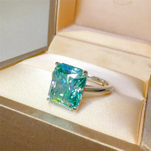 Emerald cut moissanite ring in silver with architectural design and bright brilliance.