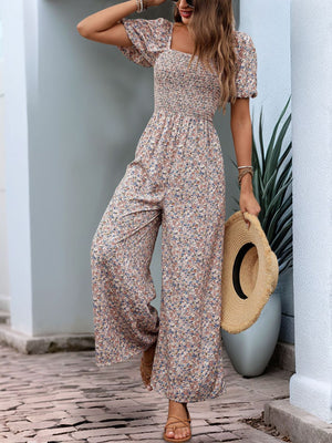 Floral smocked bodice wide leg jumpsuit with puff sleeves and a square neckline.