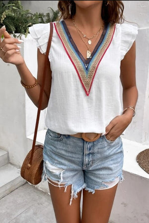 White flutter sleeve blouse with colorful embroidered V-neck trim and ruffle sleeves.