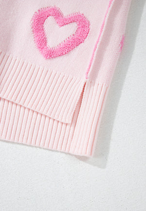 Pink knit sweater with heart appliqué and balloon sleeves.