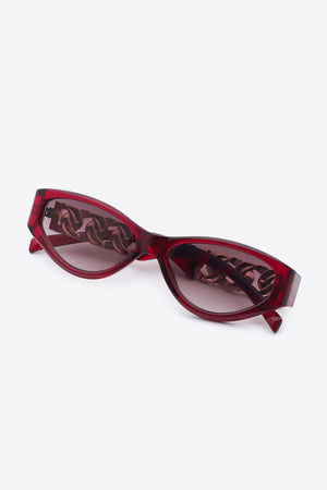 Deep Red cat-eye sunglasses with white frame and chain detail.