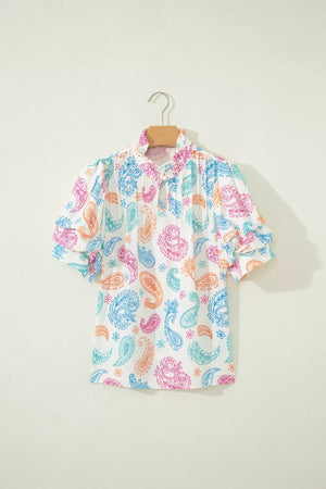 Maternity blouse with vibrant paisley print, puff sleeves, and keyhole neckline.