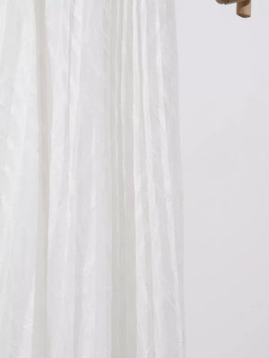 White maxi dress with textured vertical stripes and flowing fabric detail