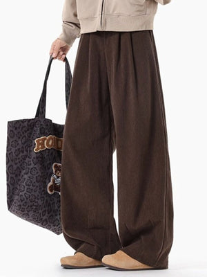 Men's brown pleated wide leg trousers with a relaxed fit