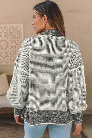 Textured open-front knit cardigan in black and cream with a waffle knit pattern and contrasting hem.