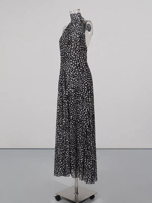 Black and white polka dot halter maxi dress with a flowing skirt.