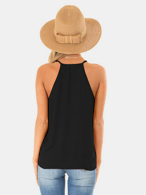 Black draped crossover halter cami with thin straps and a relaxed fit.