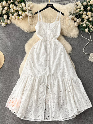White lace-embroidered cami dress with tiered skirt and cutout details.
