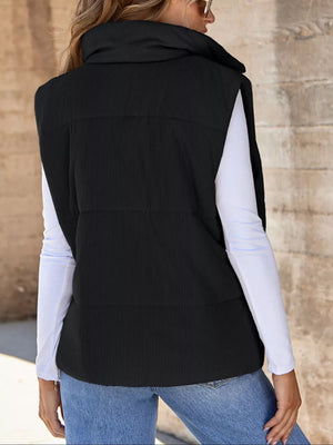 Black ribbed corduroy zip-up vest coat with high collar and quilted detail.
