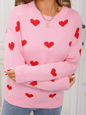 Pink acrylic sweater with red heart print, crew neck, and long sleeves.