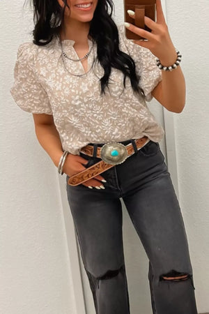 Charming floral jacquard shirt with puff sleeves and a frill neckline, worn with grey ripped jeans.