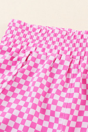 Pink checkered shorts with elastic waistband and drawstring detail.