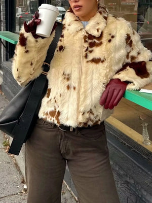 Cropped faux fur zip up jacket in beige with brown spots, featuring a collar and zip closure.