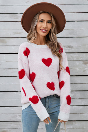 White crewneck sweater with red heart appliqué, long sleeves, casual knit style
