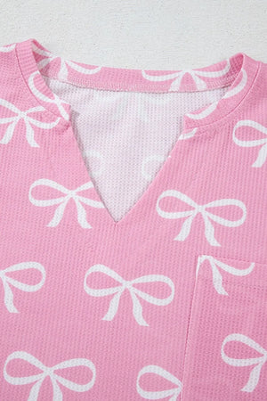 Pink ribbed lounge set with white bow print and V-neck detail.