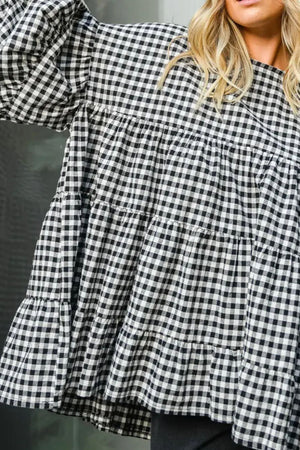 Gingham tiered blouson sleeve top in plaid with ruffled hem and cuffs.