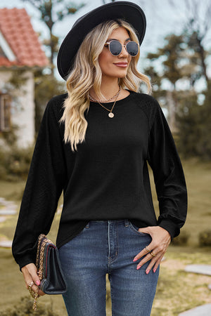 Black waffle knit eyelet raglan sleeve top with crewneck and long sleeves.