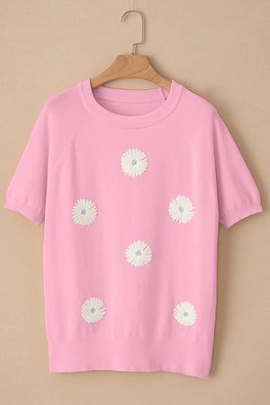 Pink knit top with daisy appliqués, crew neck, and short sleeves.