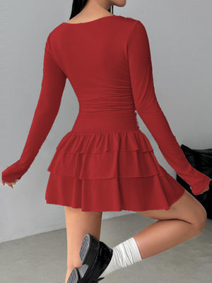 Red long sleeve mini dress with tiered ruffle hem and ruched sides.