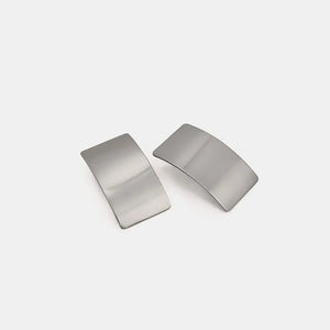 Sculpted silver-tone statement earrings with a bold, curved design.