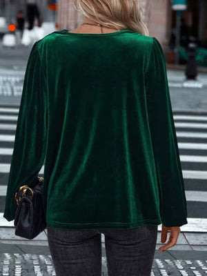 Dark green velvet cowl neck shirt with long sleeves and puff shoulders.