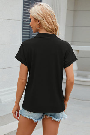 Black textured polo top with cuffed short sleeves and a collar.