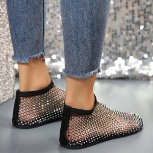Glistening rhinestone mesh flats with round toe, black trim, and ankle-high cut.
