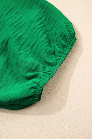 Green ruched polyester maternity shirt with a textured fabric and elasticated hem.