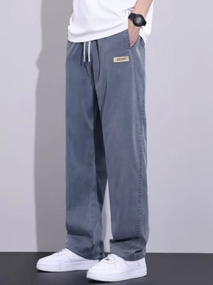 Men's grey relaxed fit sweatpants with drawstring and patch detail.