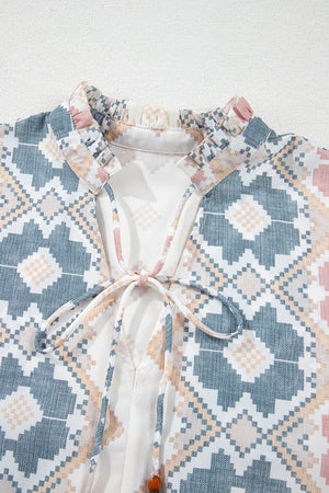 Geometric print blouse with ruffle neck and tassel tie detail in floral colors.