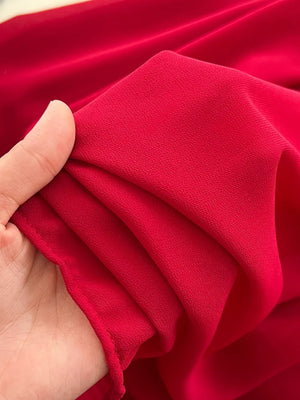 Red maternity maxi dress fabric detail, showing textured crepe material.