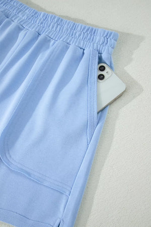 Light blue pocketed shorts with elastic waistband and phone detail.