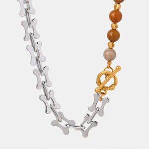 Silver asymmetrical chain necklace with bone links and beaded section with toggle clasp.