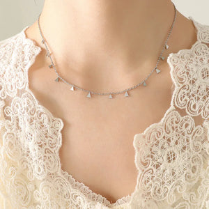 Silver necklace with dangling triangle charms on a delicate chain