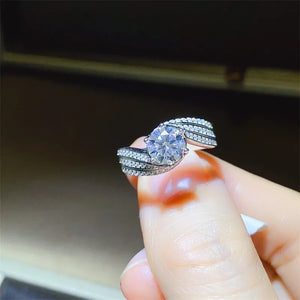 Silver swirl band ring with a large center moissanite and pave-set stones.